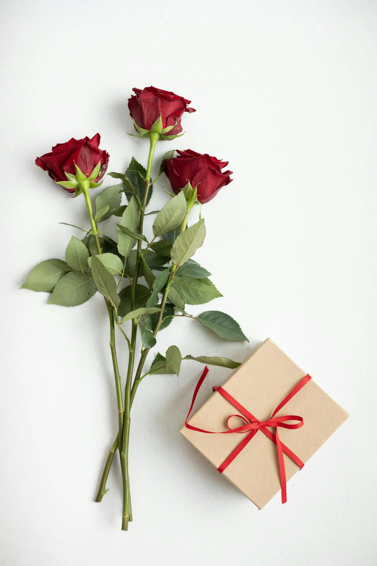 A gift box with fresh flowers arranged beside it