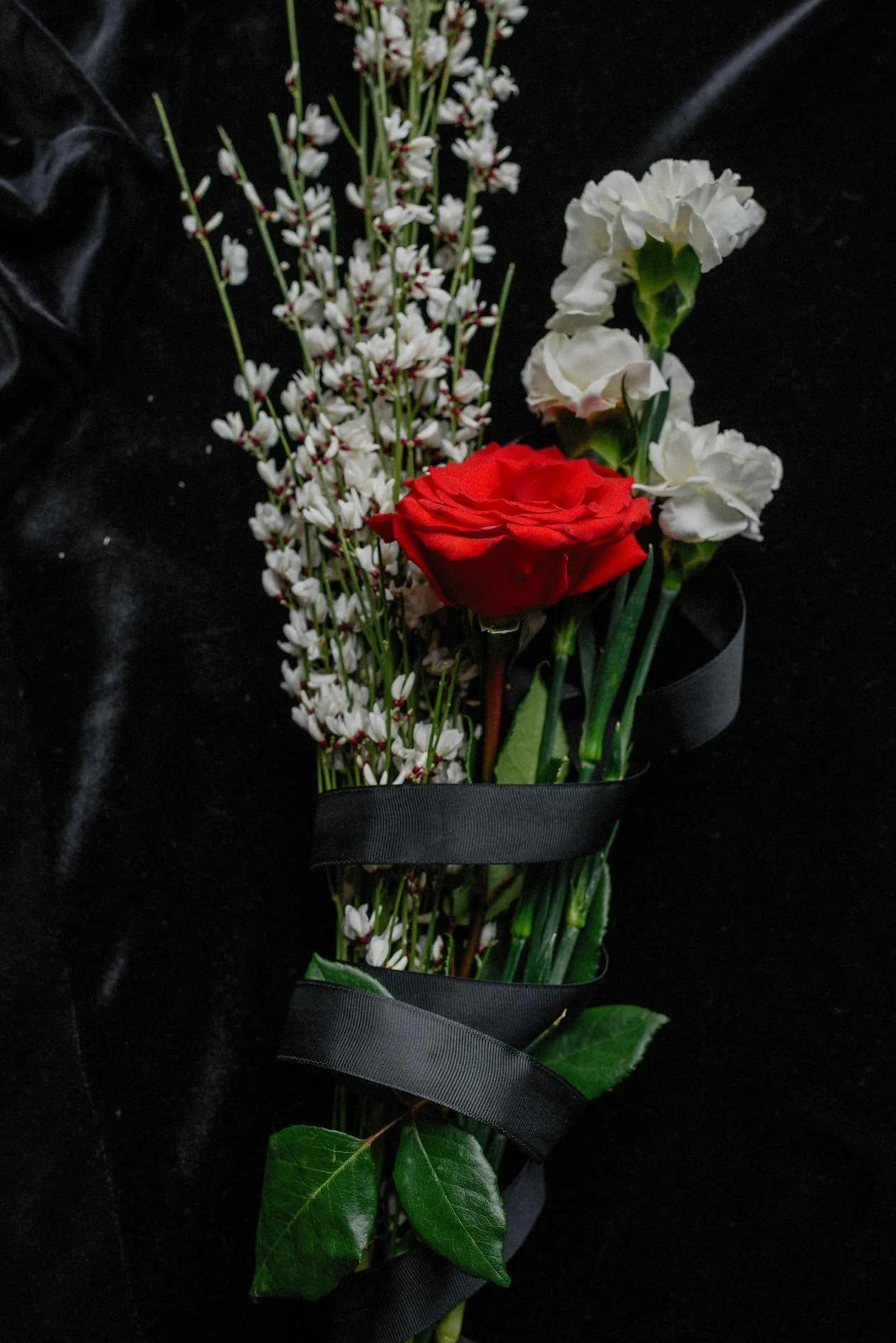 A flower bouquet wrapped with black ribbon ready for delivery